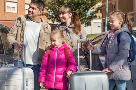 Parents with two amazing daughters with suitcases in journeyの写真素材