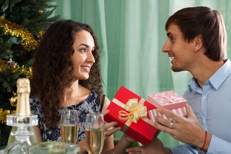 guy giving present to girl during dinner in homeの写真素材