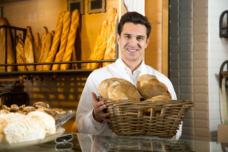 Man selling fresh pastry and baguettes in local bakery or coffe-house,cafeteria,cafe