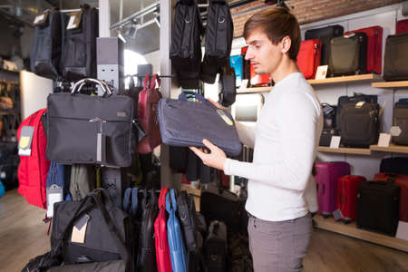 Guy buying textile new bag in haberdashery shopの写真素材