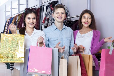 Young people in a clothing store with shopping bags in their handsの写真素材