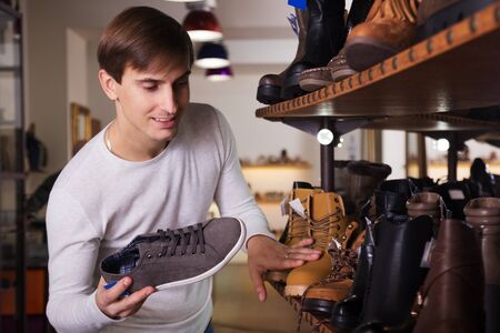 Guy are looking for a winer shoes in the shoe shopの写真素材