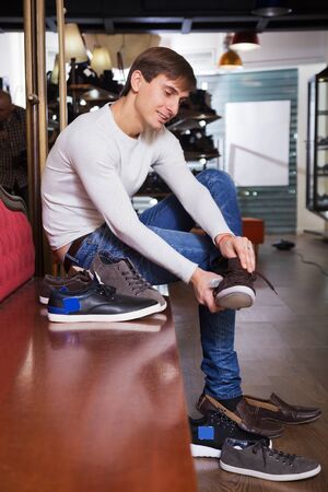 Young man wants to buy the summer shoesの写真素材