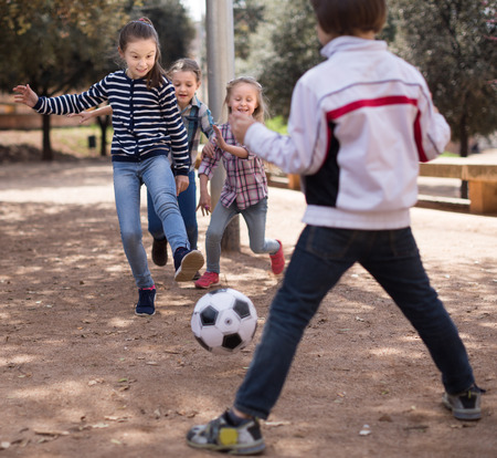 ordinary Children play with a ball outdoors in the springの写真素材