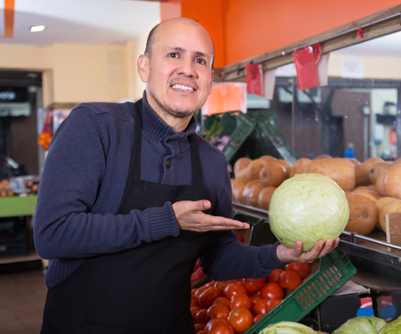 Friendly sellers offering fresh cabbage in the marketの写真素材