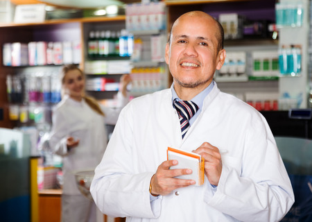 Smiling man pharmacist in  chemist's shopの写真素材