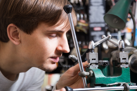 Friendly man professional making key in locksmithの写真素材