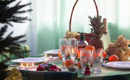 Christmas still life with candles and glasses on tableの写真素材