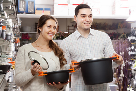 Man and woman buying pans in shop cookwareの写真素材
