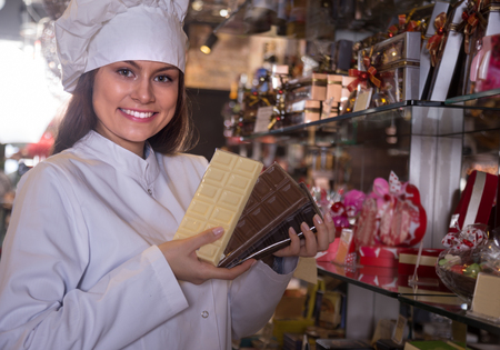 Portrait of young woman selling fine chocolates and confectionery in cafeの写真素材