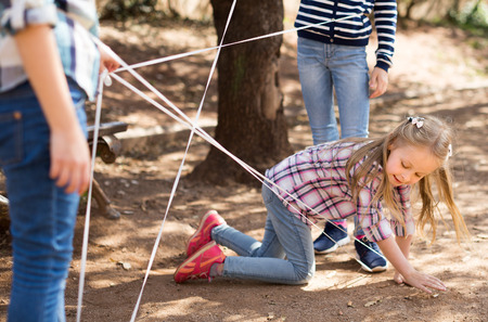 children games. Girl gently goes through the tangled ropeの写真素材
