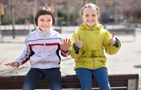 boy with blond girl posing on street bench in the Indian summerの写真素材