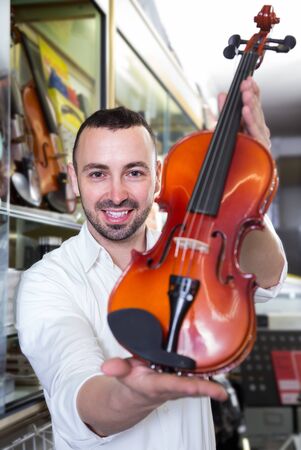
customer selecting classical violin in music instruments storeの写真素材