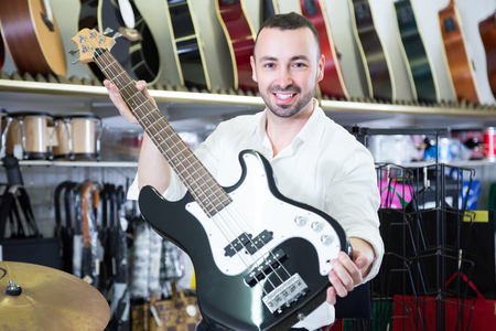 Male buyer choosing electric guitar in music storeの写真素材