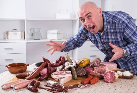 portrait of ordinary men with lots of meat and sausage productsの写真素材