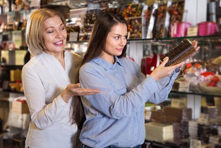 
Happy female customers buying dark and white chocolate in sweet-shopの写真素材