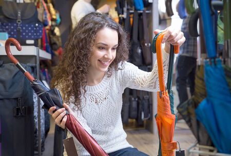 Young woman purchasing umbrella in haberdashery shopの写真素材