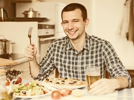 happy gay dinner pizza salad in the kitchen at homeの写真素材