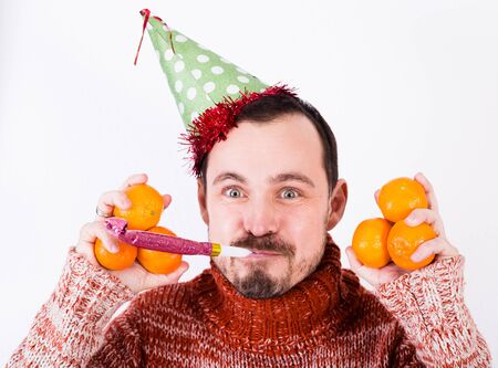 Portrait of fanny guy on holiday in hat and whistle with tangerinesの写真素材