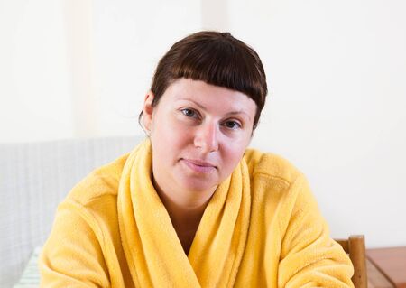 Women in yellow bathrobe at homeの写真素材