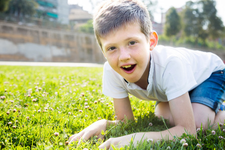 surprised boy sitting grassの写真素材