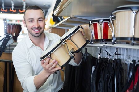Male customer choosing drums and accessories in music storeの写真素材
