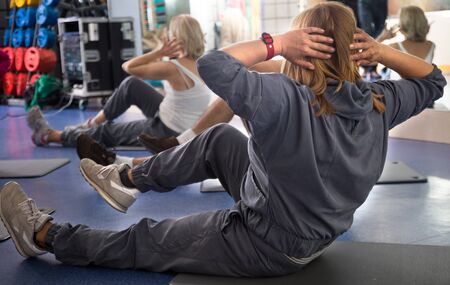 active mature women are engaged on mat in gym