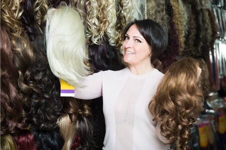 middle aged brunette woman stylish wig in storeの写真素材