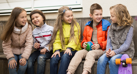 smiling Children on bench playing children's gamesの写真素材