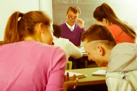 senior Professor watching as student write off on exams at universityの写真素材