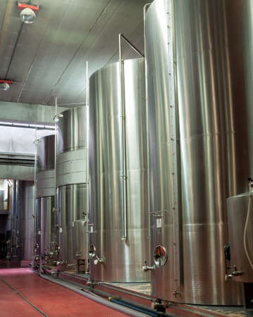 modern Stainless steel wine reservoirs  in a row inside the modern factory in Spain