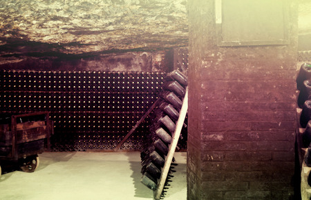 old and dusty wine bottles in cave cellar in wineryの写真素材