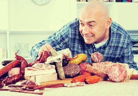 portrait of ordinary men with lots of meat and sausage productsの写真素材