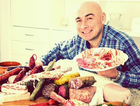 ordinary man posing with a plate of cold cutsの写真素材