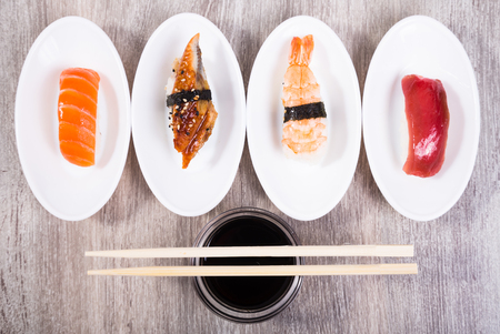 four kinds of Nigirisushi on oval white saucersの写真素材