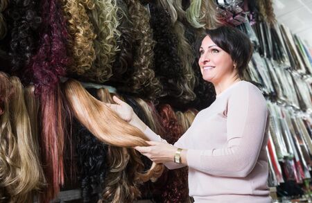 Ordinary female customer buying at different color hair extensions in salonの写真素材