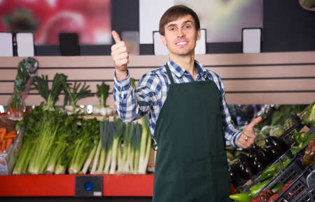 Portrait of young male posing in grocery and smilingの写真素材