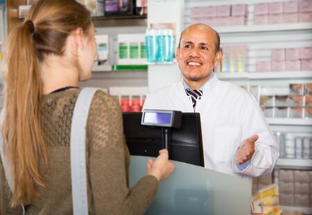 blonde woman buying drugs in a drugstoreの写真素材