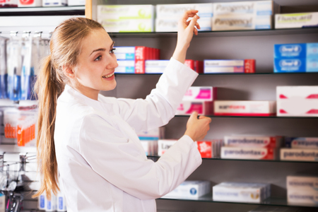 Smiling woman pharmatics posing in drugstoreの写真素材