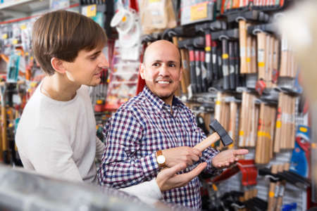 mature Male client and young salesman at tooling section in building storeの写真素材