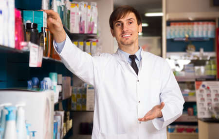 smiling male pharmacists working in modern farmacyの写真素材
