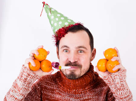 Portrait of Man on holiday in hat and whistle with tangerinesの写真素材