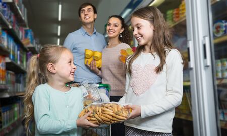 Middle-class satisfaction family of four doing shopping in hypermarketの写真素材