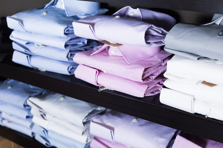 collection of shirts on shelfs in men clothing storeの写真素材