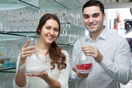 young couple looking at glassware at storeの写真素材