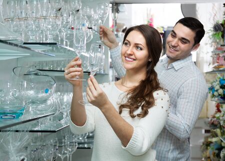 young female and male looking at glassware at shopの写真素材