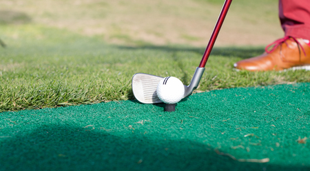 iron to ball and takes aim at the golf courseの写真素材