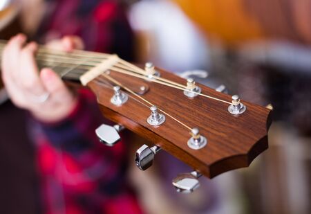 girl holding guitar. Focus on the head of Six-string guitarの写真素材