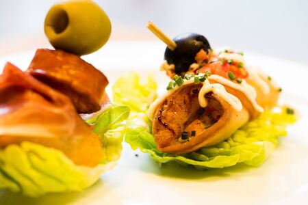 delicious pinchos with olives on salad leafの写真素材