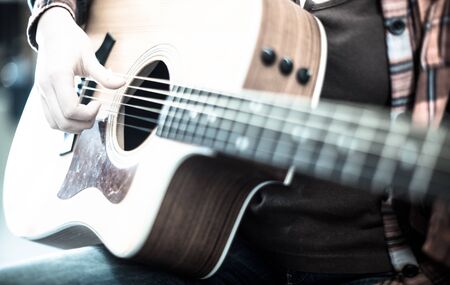 girl holding guitar. Focus on fingers playing guitarの写真素材